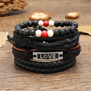Retro multi-layer braided leather bracelet set with LOVE engraving on a dark wood background