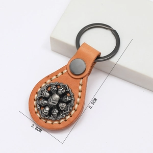 Porte-clés artisanal en cuir marron avec relief de crâne en argent vintage