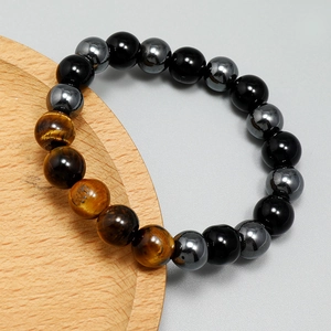 Men's Tiger Eye beaded bracelet with Hematite and Black Onyx stones on wooden tray