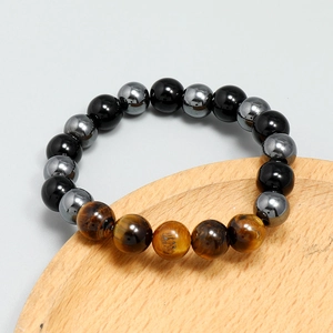 Detail of tiger eye, obsidian, and hematite beaded bracelet on a wood display