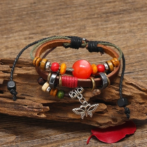Multilayer leather beaded bracelet with butterfly pendant on a rustic wood branch