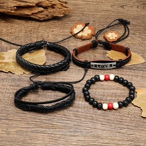 Vintage retro braided leather bracelet set with LOVE metal plate on a rustic wood background