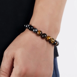 Men's minimalist tiger eye and obsidian beaded stretch bracelet worn on wrist