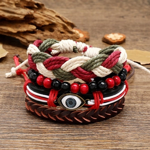 Bohemian multi-layer leather bracelet set with evil eye charm and woven rope on wood