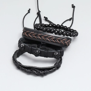 Set of four vintage punk leather bracelets featuring black beads and skull decorations