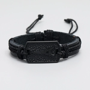 Detail of adjustable black woven leather bracelet with Eiffel Tower metal plate engraving