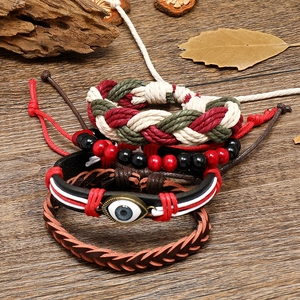 Close-up of Bohemian leather bracelets with Evil Eye charm on a rustic wood background