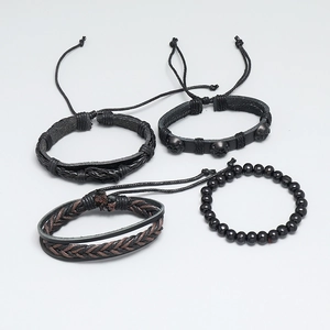Close-up of four-piece vintage braided leather bracelet set with skull charms and beads