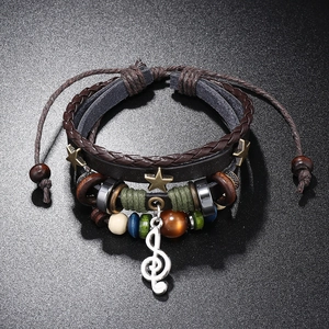 Detail of multi-layer leather bracelet with star charms and treble clef note pendant