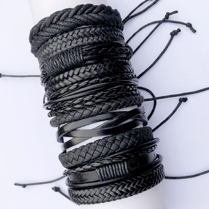 Détail de bracelets multicouches en cuir tressé noir avec cordons coulissants réglables