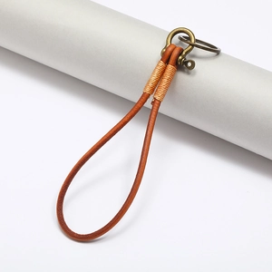 Handcrafted brown leather keychain with vintage bronze horseshoe buckle on a minimalist display