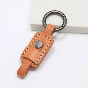 Macro shot of handcrafted brown leather keychain with white stitching and metal ring