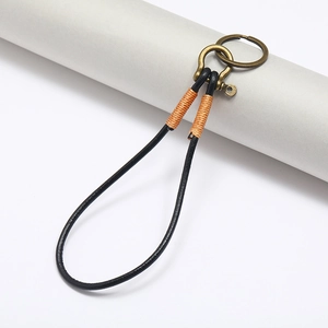 Detail of vintage leather keychain with bronze horseshoe buckle and orange wrap