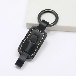 Detail of premium black leather keychain with white contrast stitching and grey metal ring
