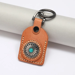 Detail of vintage leather keychain with hand-stitched seams and turquoise stone inlay