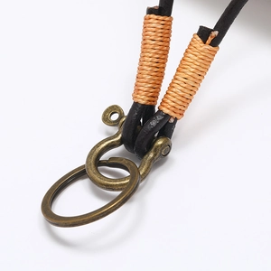 Close-up of vintage brown leather strap with orange thread wrap and brass U-ring clasp