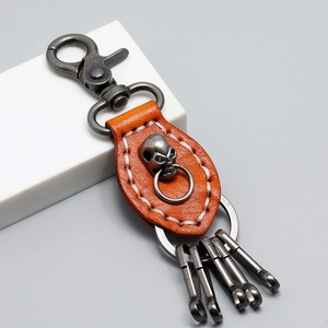 Vintage orange leather skull keychain with heavy-duty metal hooks in a 45-degree angle view