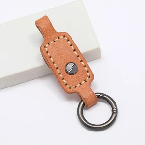 Detail of brown leather keychain with white hand-stitching and metal spring ring