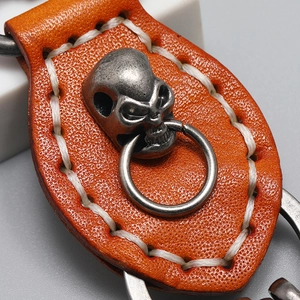 Handmade orange cowhide leather keychain with vintage skull detail and white stitching