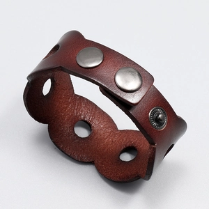 Detail view of brown leather wide bracelet with metal rivets and hollow punch design