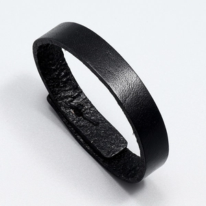 Close-up of black leather wide bracelet showing natural grain texture and stitching