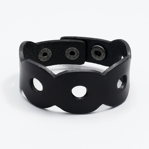 Macro view of wide black leather wristband with wave edges and silver metallic snap buttons