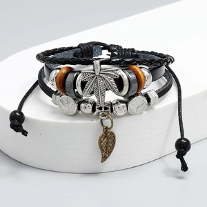 Detail of multi-layer leather bracelet featuring metal leaf charms and wood beads