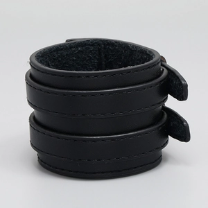 Close-up of black leather punk wristband featuring double buckle straps and stitch details