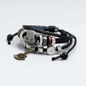 Detail of multi-layer leather bracelet with metal skull, rudder charms and wooden beads