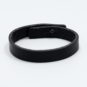 Detailed close-up of handmade black leather bracelet showing natural textured grain