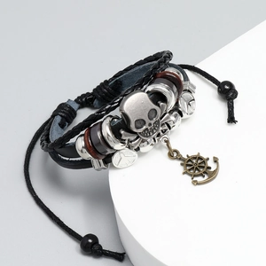 Close-up of multilayer leather bracelet with skull and bronze anchor charms