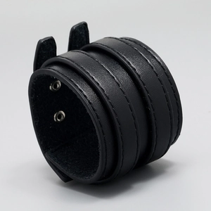Detail view of black punk leather bracelet showing double-layer stitching and silver snap buttons