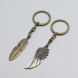 Close-up of vintage bronze wing and feather metal keychains with detailed textures