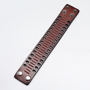 Detail of vintage wide leather cuff with oval cut-outs and metallic button clasps