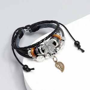 Detail of multi-layer leather bracelet featuring a silver hemp leaf and bronze leaf charm