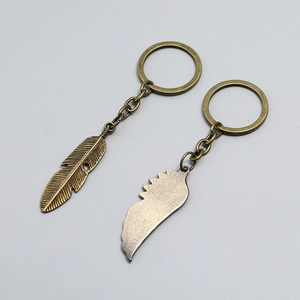 Vintage bronze wing and feather keychain set with antique finish on light background