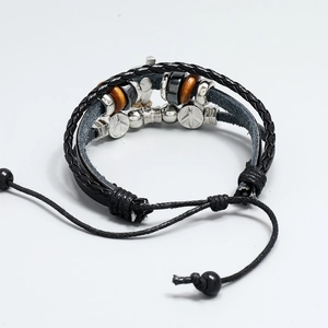 Detail of multi-layer leather bracelet with cross charms and wooden beads on white