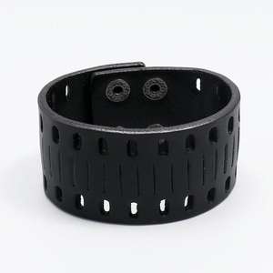 Detail of punk style wide black leather bracelet with hollow cutouts and metal snap buttons