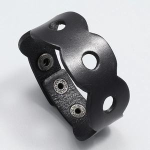 Detailed close-up of a wide black leather punk bracelet with silver snap buttons