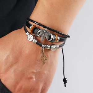 Detail of layered leather bracelet with hemp leaf charm and vintage beads for men