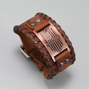 Macro detail of brown leather braided bracelet with metal plaque and rivet hardware