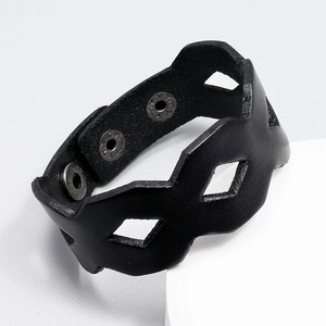 Macro shot of black wide leather bracelet with geometric hollow pattern and metal snaps