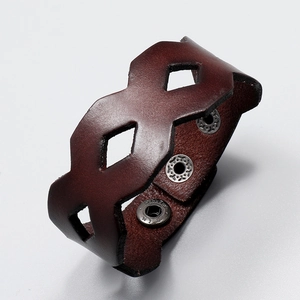 Detail view of dark brown leather wide cuff with hollow diamond cutouts and metal snaps
