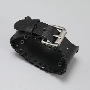 Detail eines schwarzen Lederarmbands mit Vintage-Schnalle und geflochtenen Kanten