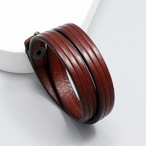 Close-up of vintage multi-layer brown genuine leather bracelet with metal snap button
