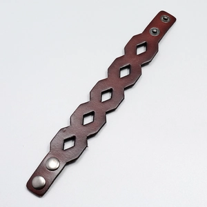 Close-up of brown vintage leather bracelet with geometric cutouts and metal snaps