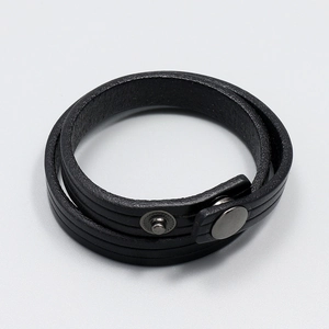 Close-up of double-wrap black leather bracelet with gunmetal clasp and stitching details