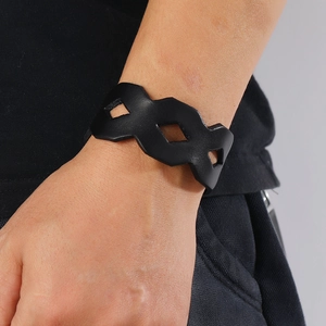 Detail of minimalist black leather wristband with geometric cutout diamond pattern