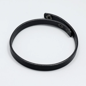 Detail of black layered leather bracelet showing adjustable metal snap buttons and edge craft