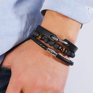 Men's 3-piece bracelet set with black leather, lava stone, and woven cord on wrist